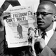 Malcolm X holds up a paper for the crowd to see during a Black Muslim rally in New York City on Aug. 6, 1963.